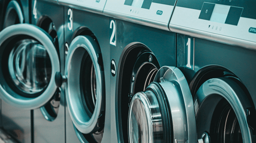 A row of washing machines lined up sequentially.