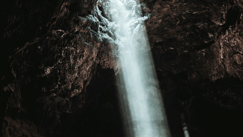 image of a cave with a beam of light coming from the roof of the cave