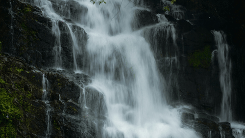 A waterfall with gushing waters surrounded by rocks.