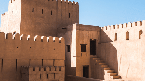 A fort with doors and steps leading to different rooms inside and the blue sky in the background