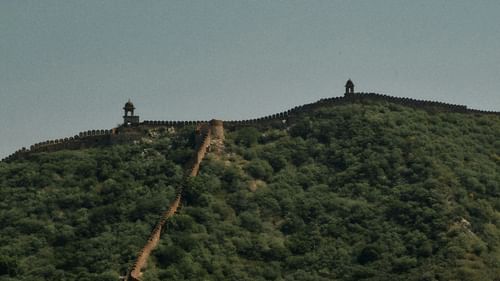 an image of a fort on top of a lush mountain