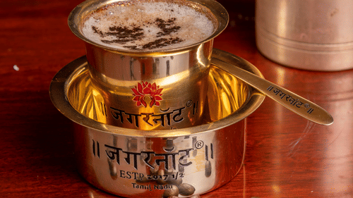 a close up shot of a South Indian Filter coffee serves in a steel cup