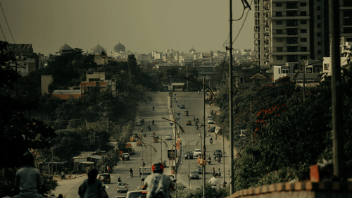 Traffic moving along on a road with trees in the background