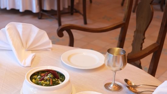 Two Mouthwatering Indian curries plated in white fancy utensils at the restaurant - Goose in Clarks Amer, Jaipur