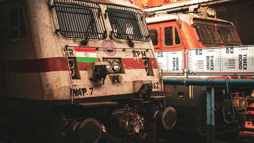 A train engine at a railway platform, showing rail equipment and station surroundings.
