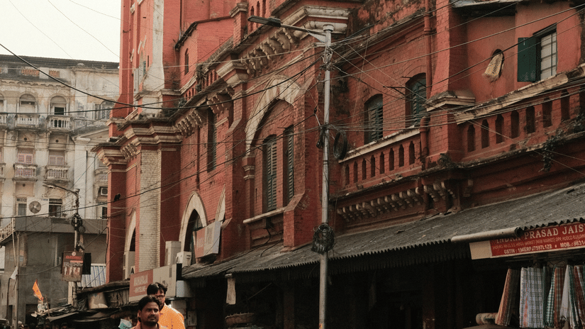 Kolkata New Market area with the market and the clock towel in view with the road and people travelling on it