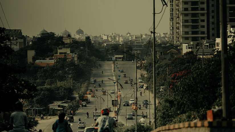 Traffic moving along on a road with trees in the background