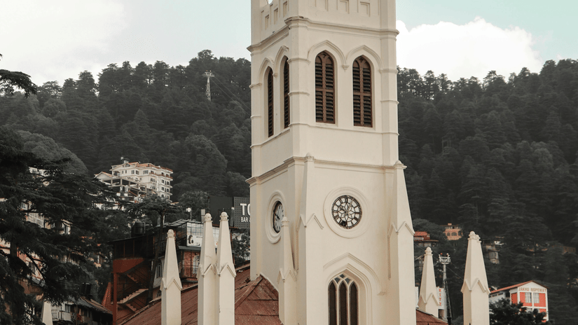 The historic Christ Church in Shimla, with its pale stone tower rising above a busy pedestrian area.