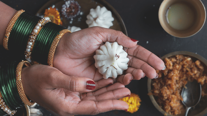 A top-down view of a person holding a modak sweet, primarily made during Ganesh chaturthi.