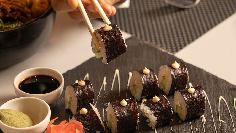 A plate of sushi with a hand picking it up at Ananta Spa and Resort, Ajabgarh