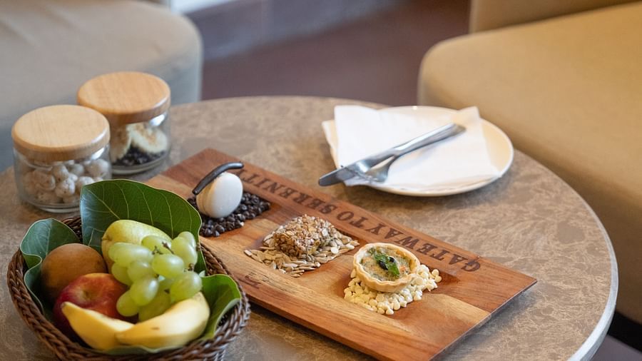 Close-up of a table set with fruit bowl, cutlery, and snacks at Ananta Spa and Resort, Ajabgarh.