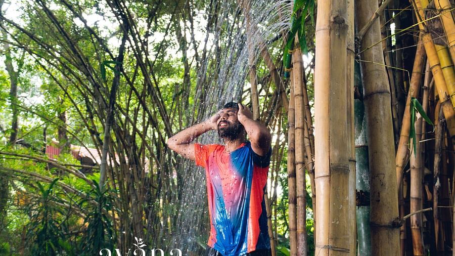 A person walking on a rope bridge or obstacle course in a lush, green outdoor setting.