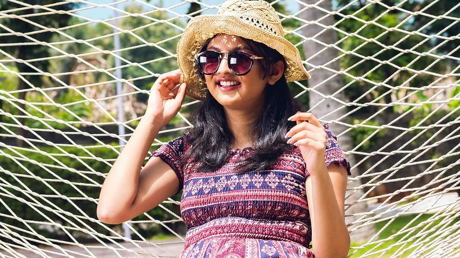 A women relaxing in a hammock outdoors, surrounded by greenery.