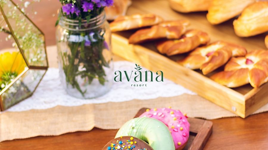 Pastries and cookies served with a flower vase on an outdoor table. 