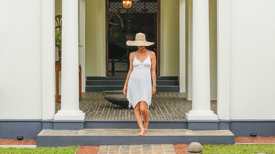 A grand white villa with a walkway leading to the entrance, featuring a guest walking through - Heavensa Villas and Suites by the Clarks, Galle