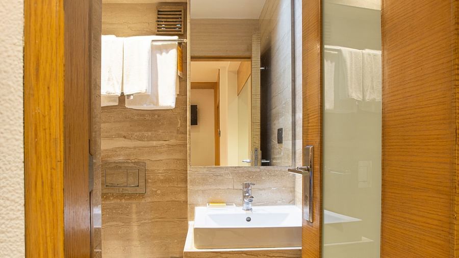 A view of a modernly furnished attached bathroom, showcasing sleek fixtures, stylish cabinetry, and contemporary design elements