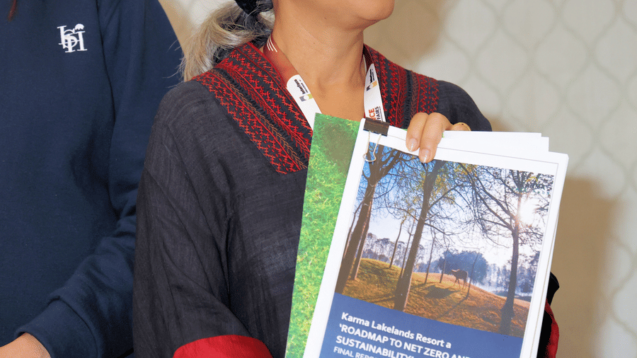 Image of a person holding a book and posing for the picture - Karma Lakelands.