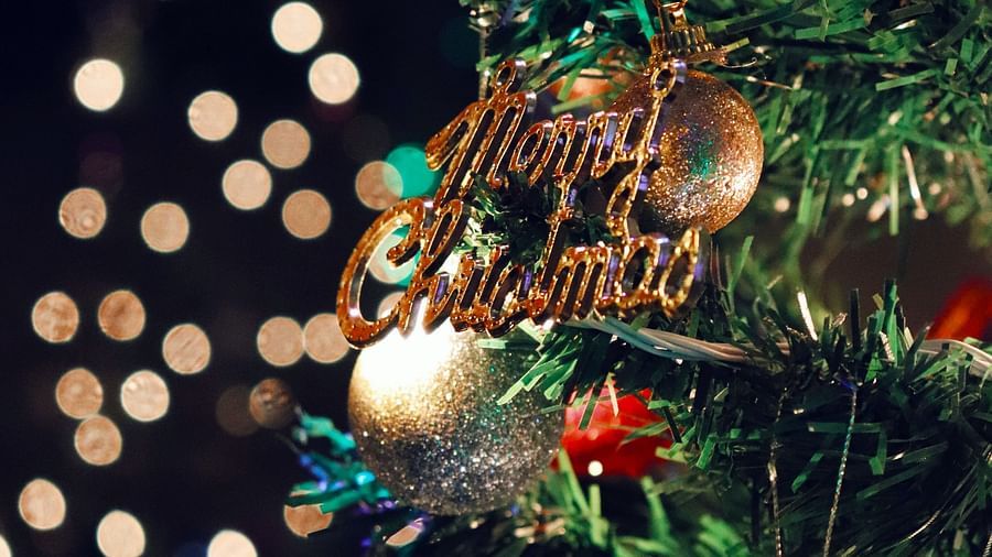 a christmas tree decorated with merry christmas ornament on it and other ornaments as well