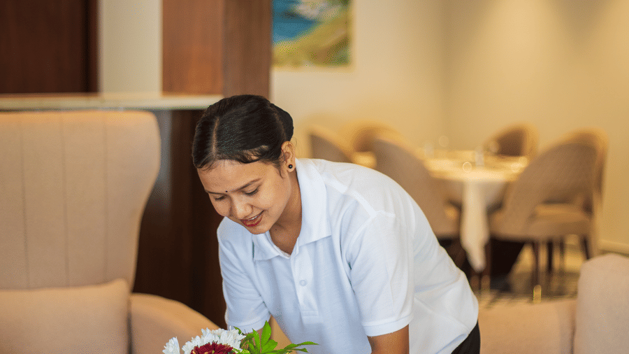 Hotel staff arranging a floral centrepiece in a lounge area - Lamrin Morjim Goa