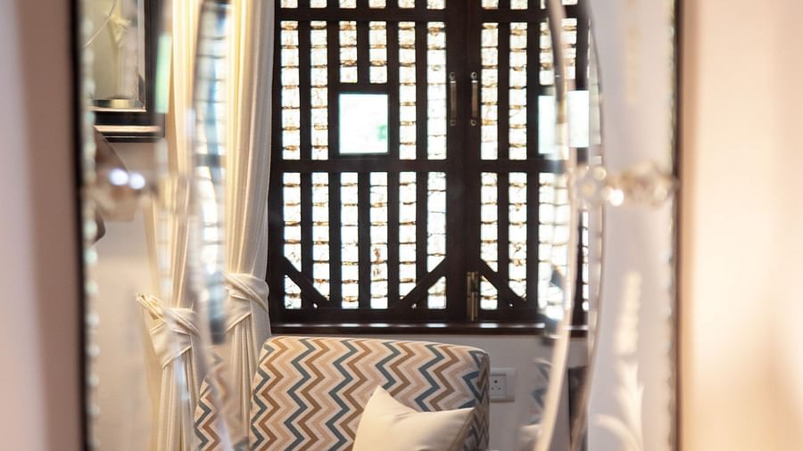 An image of a beautiful mirror and sofa in its reflection  @ Lamrin Ucassaim Hotel, Goa