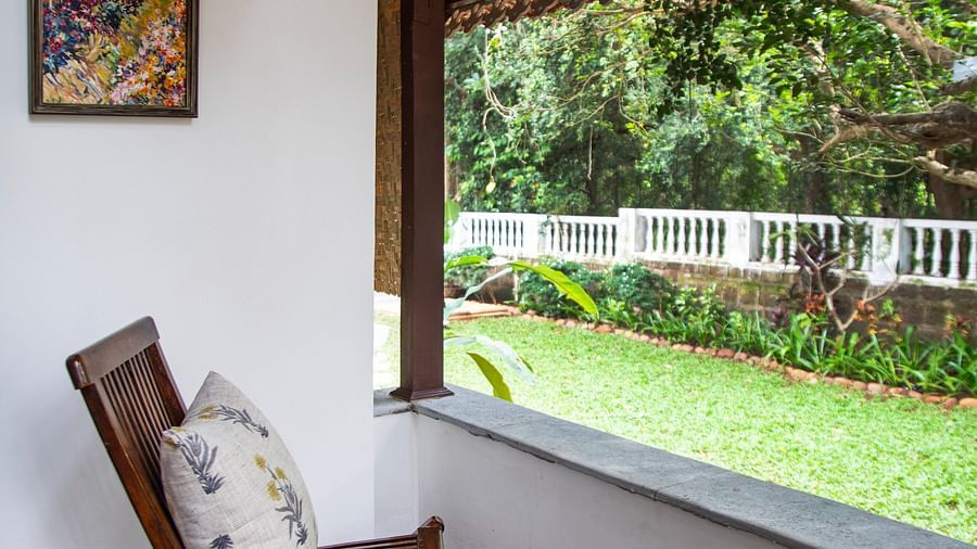 two wooden chairs looking out into greenery  @ Lamrin Ucassaim Hotel, Goa