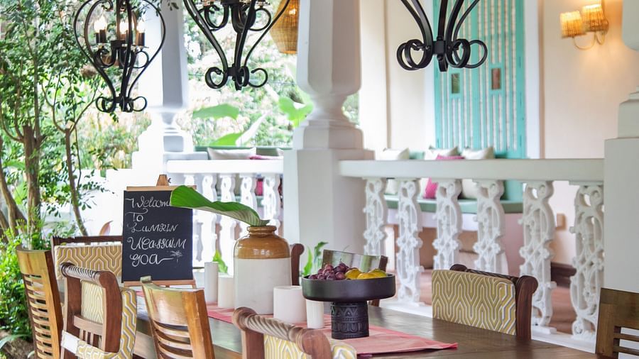 An image of a dining table setting in the courtyard of Lamrin Ucassaim Hotel, Goa