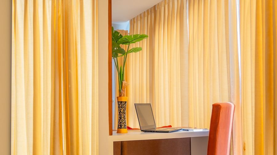A work desk and chair placed next to a mirror in a Standard Room at Montclair Ananta, Elite.