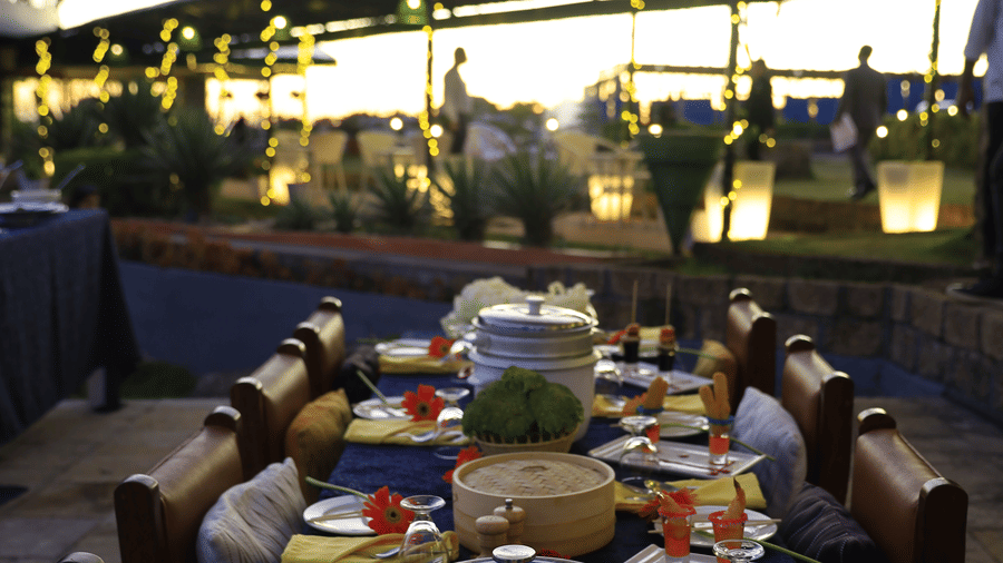 Dining area featuring several tables with food items and chairs on either side Polo Cherrapunjee Resort