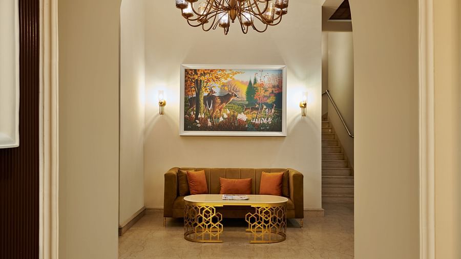 a arch leading to a hallway with a sofa at the end and a painting above it - Royal Kingdom Sarovar Portico, Pilibhit