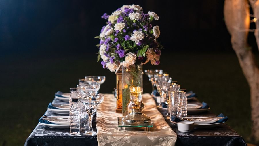 Luxurious dining table setting with silver cutlery and elegant centerpiece.