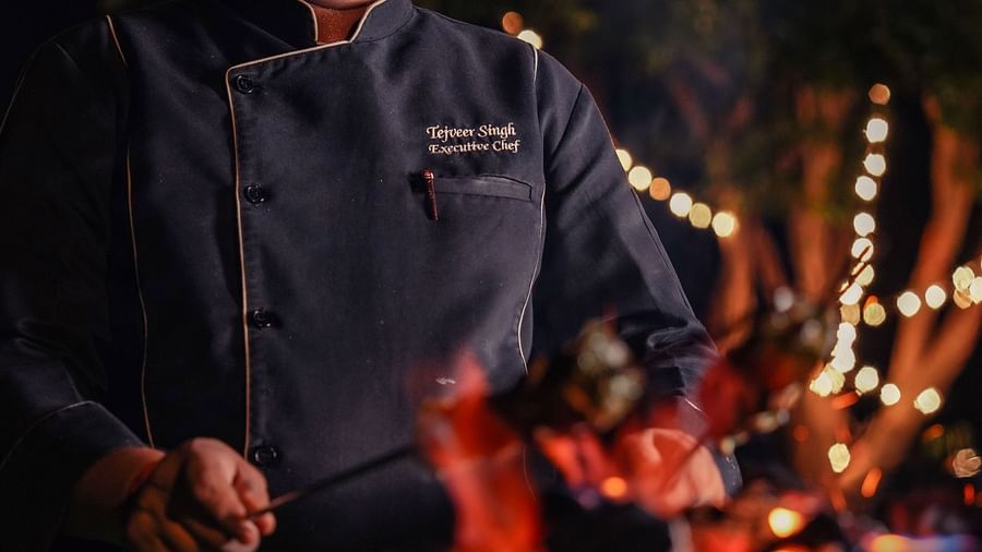 Chef preparing a gourmet meal in a dimly lit kitchen.