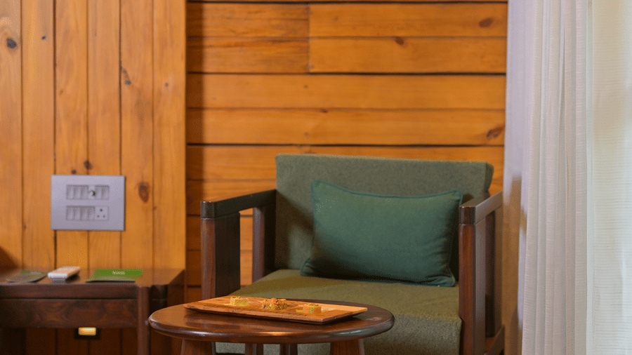 A seating area with a sofa, table, and a wall art at The Ananta Udaipur.