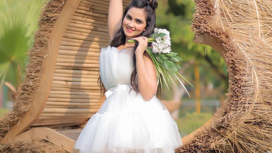 a girl standing against a heart-shaped thatched decor at Themis Mudhouse - A Nature's Retreat Resort & Wellness