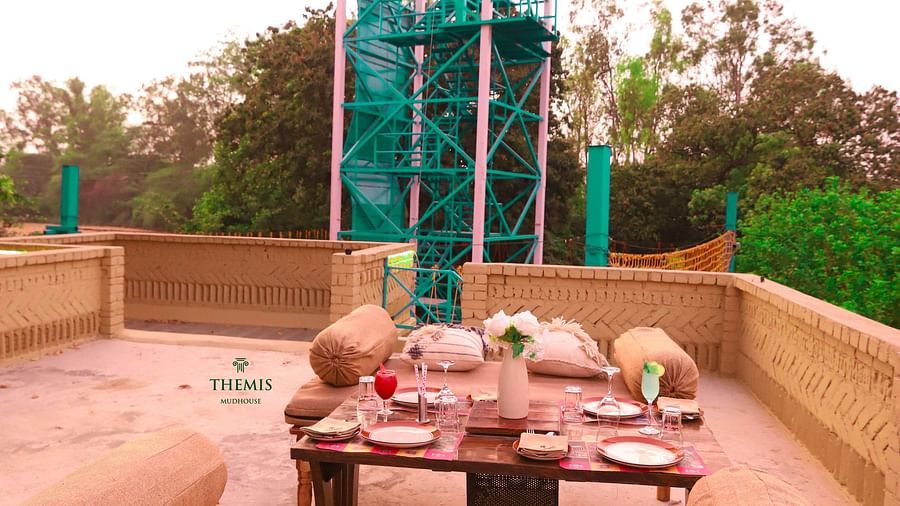 rooftop seating arrangements with a view of the zip lining platform at Themis Mudhouse - A Nature's Retreat Resort & Wellness