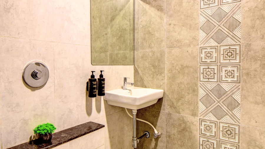 Super Deluxe Room bathroom with geometric accent tiles and vanity mirror at VITS Select Kharadi Pune