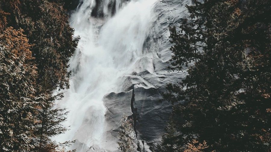 waterfall in middle of a mountain with foaming white water