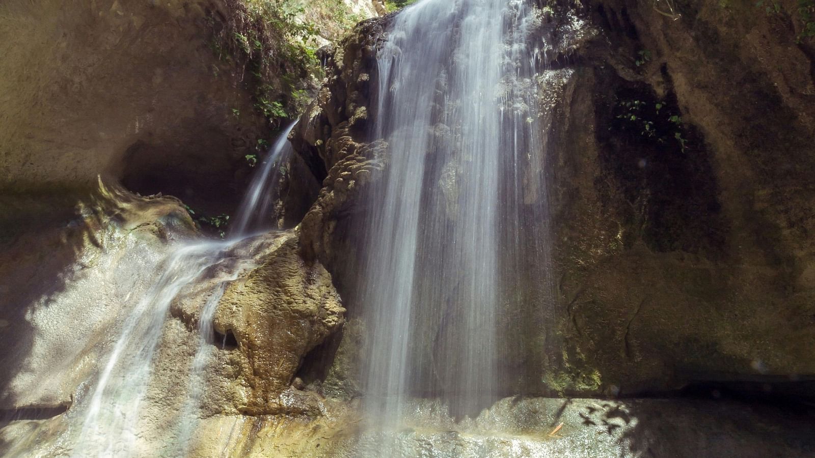 Waterfalls cascading through a rocky cliff. 