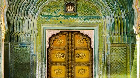 A view of the entrance to a palace with golden door surrounded by emerald archway