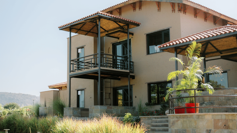 The side view of a resort building with modern architecture and surrounding landscape at Aamaghati Wildlife Resort.