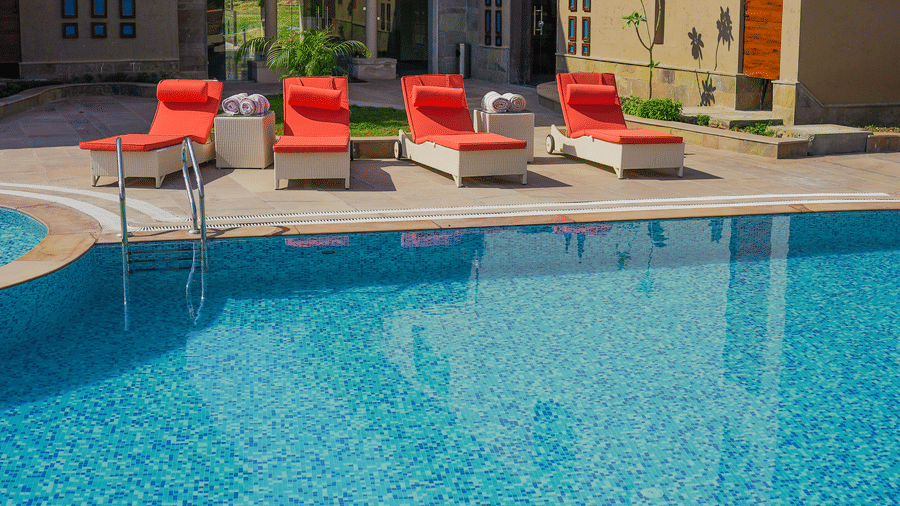 A close-up of the resort swimming pool with a decorative mosaic at its base at Aamaghati Wildlife Resort.