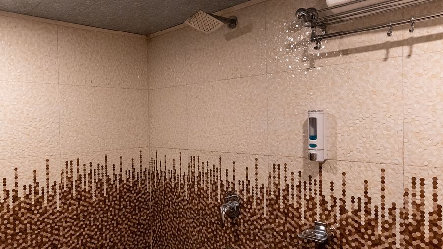 an image of a bathroom with a bucket and a mug at Avianna New Mandala Hotel & Spa, Darjeeling