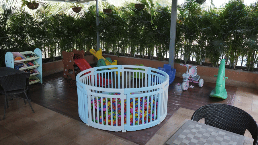 A covered play area features a ball pit, children's toys, seating options on a tiled floor at Bougainvillea, Alibaug.