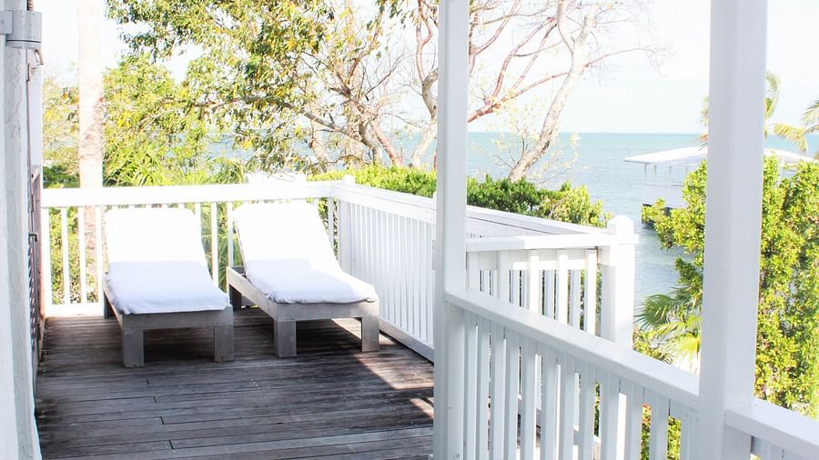 a balcony with a table and chairs overlooking greenery at casa morada.