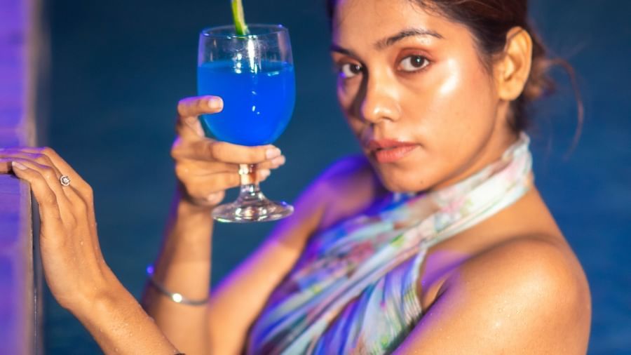 A woman posing in a swimming wear with a blue coloured drink in her hand at Daksh Resort & Amusement Park, Sasan Gir.