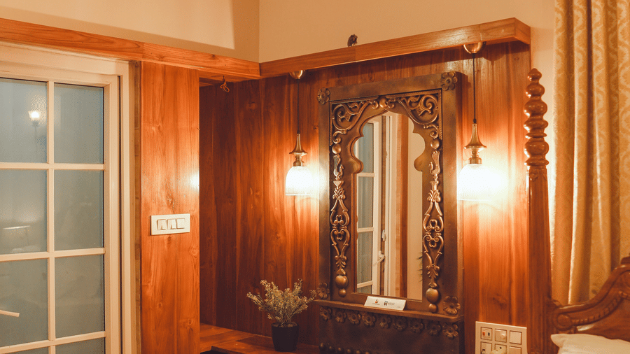 The wooden dressing table with a huge mirror with 2 lamps wall mounted beside the mirror | Dip Holidays
