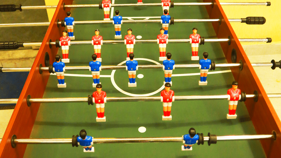 A top-down view of a table football game located in the indoor recreation area at DNC Shevaroys Resort & Spa.