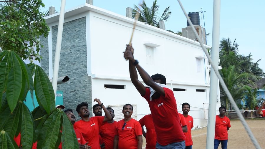 A person breaking a clay pot with blindfolds and a group of people looking at him in an outdoor area at Grande Bay Resort & Spa.