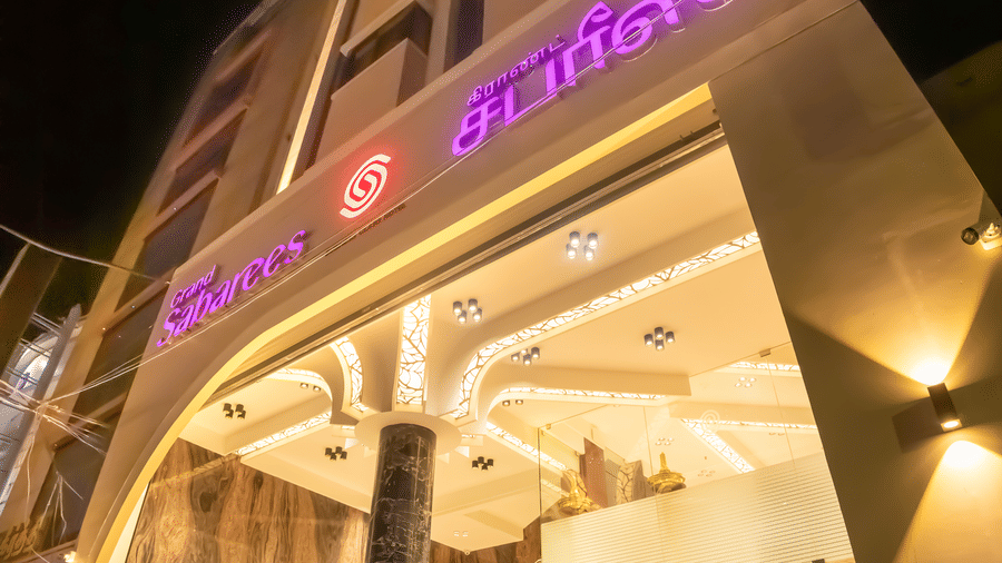 Exterior facade and illuminated entrance staircase of Hotel Grand Sabarees Madurai at night.