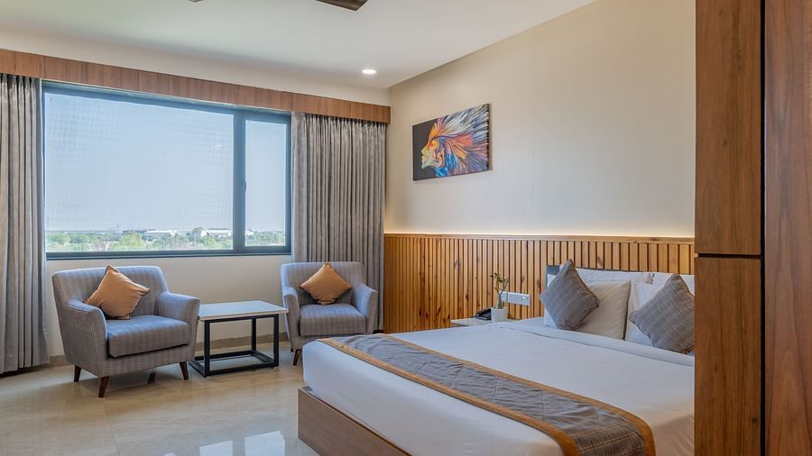 King size bed with window seating and ample natural light in a club room at Hotel Highway King, Bagru