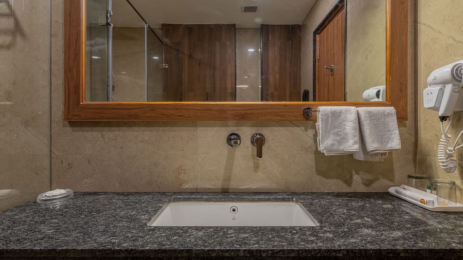 Bathroom vanity with mirror and black granite countertop at Hotel Highway King, Bagru